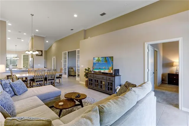 a living room with furniture kitchen view and a wooden floor