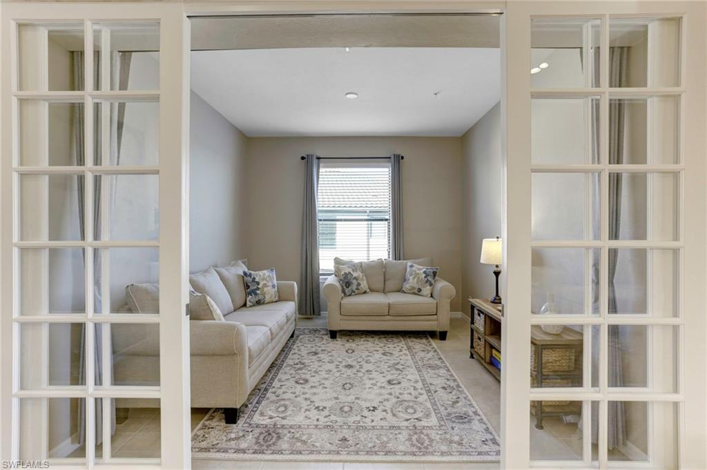 9433 Benvenuto Court, Unit 201 Naples, FL 34119 - Photo 10 of 32 a living room with furniture and windows