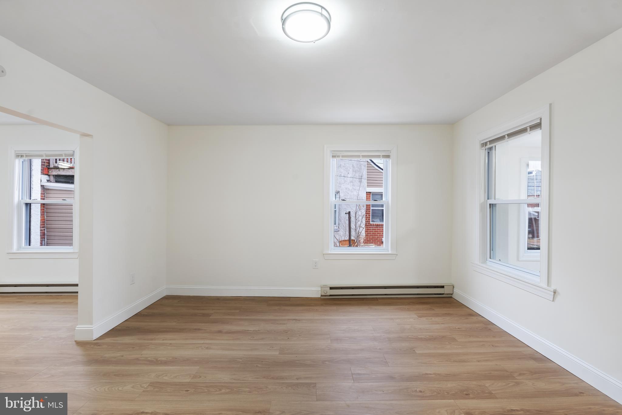 1118 Brown Street Chester, PA 19013 - Photo 13 of 27 an empty room with wooden floor and windows