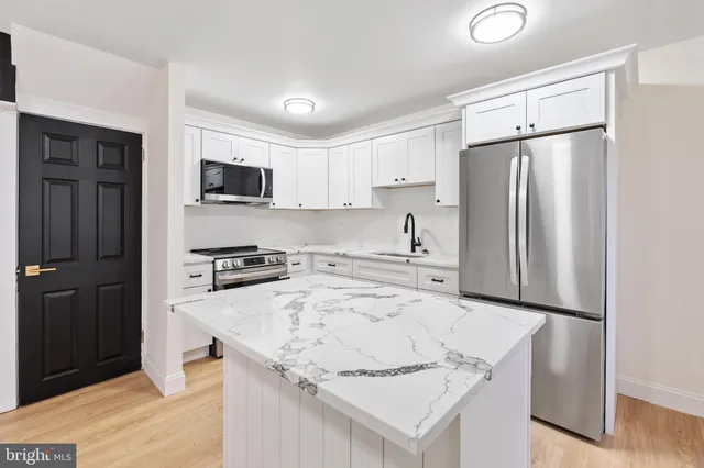 a kitchen with kitchen island a refrigerator sink and microwave