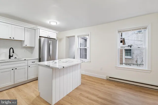 a kitchen that has a sink a stove and a refrigerator