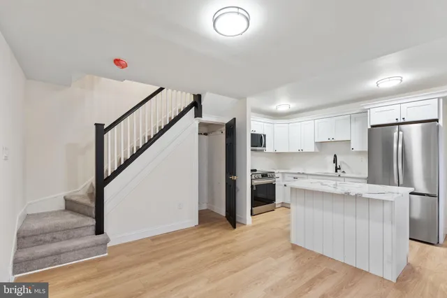 a kitchen with white cabinets and stainless steel appliances