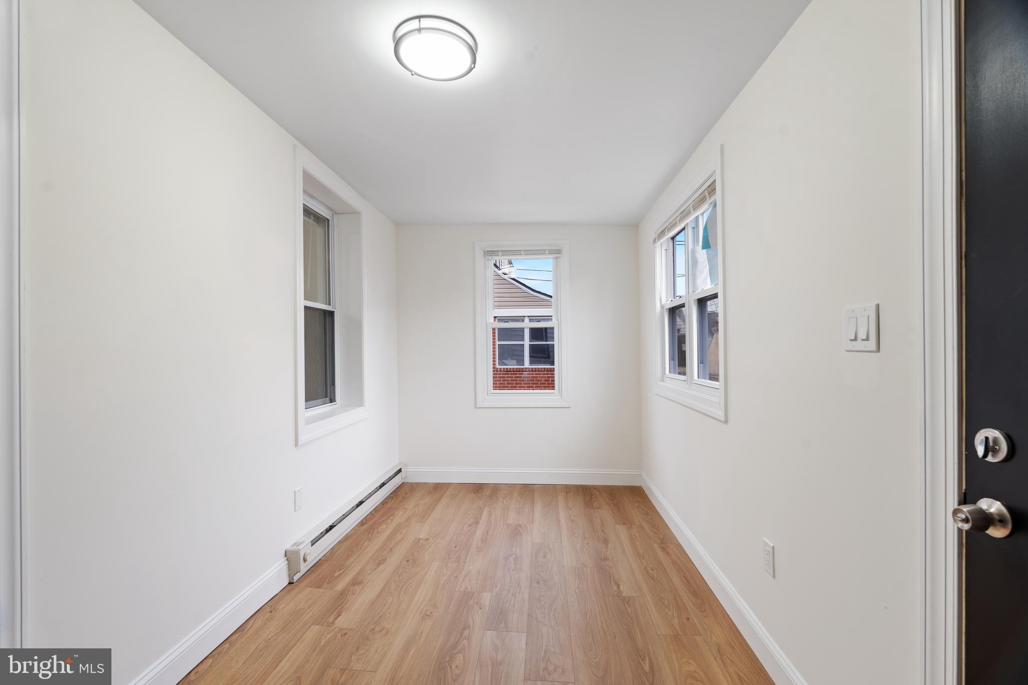 1118 Brown Street Chester, PA 19013 - Photo 10 of 27 an empty room with wooden floor and windows