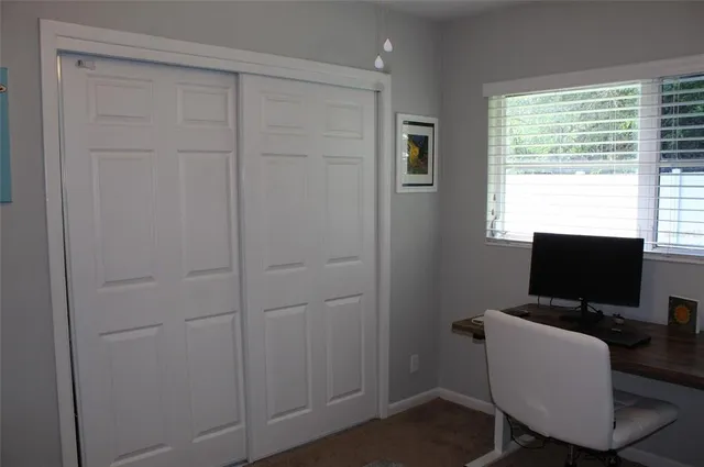 a view of a workspace with furniture and a window