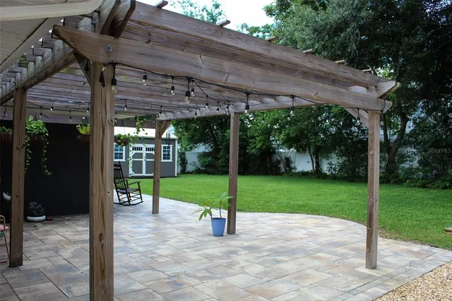 a view of a patio with a table chairs and a small yard