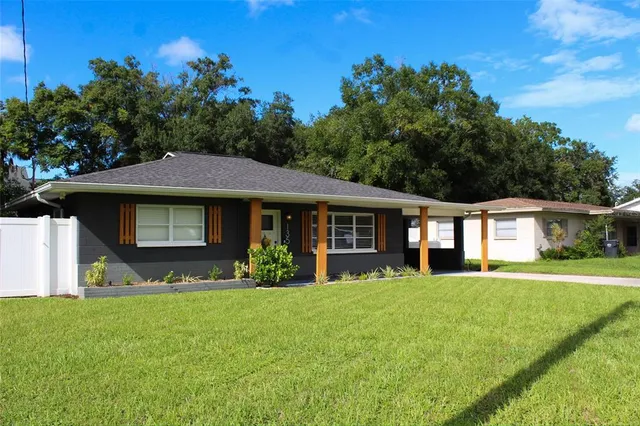 a front view of a house with a yard and trees