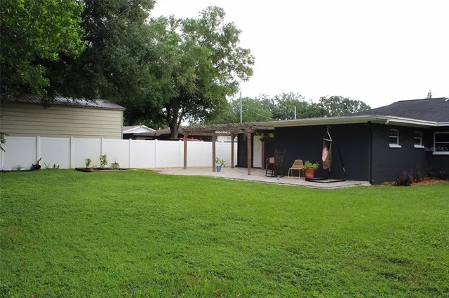 a view of a house with backyard and sitting area