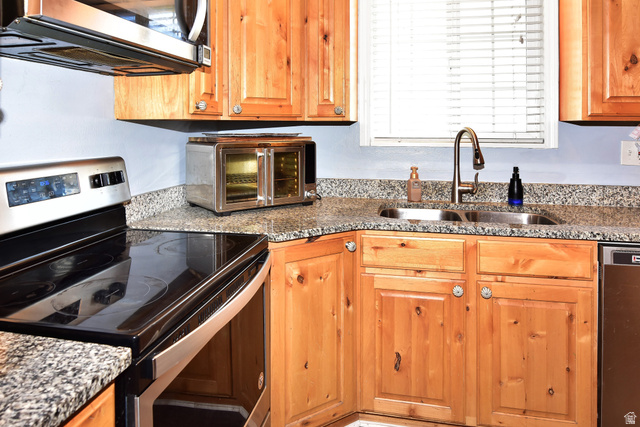 315 Park Street Inkom, ID 83245 - Photo 8 of 28 Kitchen featuring wood-finish cabinetry, granite countertops, stainless steel dual-basin sink, and a black glass-top range with a stainless steel overhead microwave