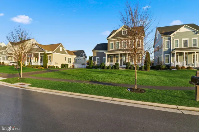 a front view of a house with a yard and trees