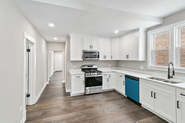 a kitchen with granite countertop white cabinets and stainless steel appliances