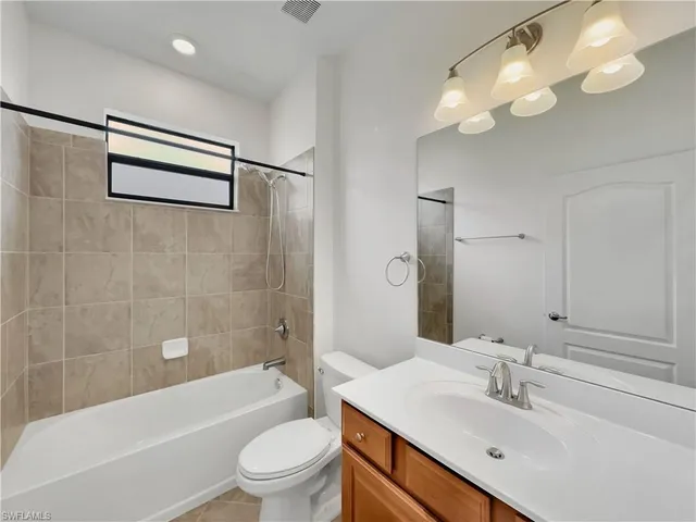 a bathroom with a sink a toilet a mirror a bathtub and shower