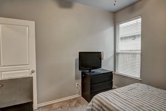 a bedroom with a bed and a television