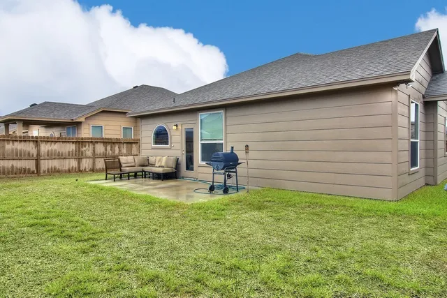 a backyard of a house with table and chairs