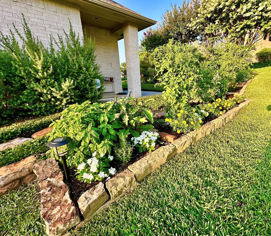 5411 Ranger Drive Rockwall, TX 75032 - Photo 24 of 33 a bunch of flowers in front of yellow house