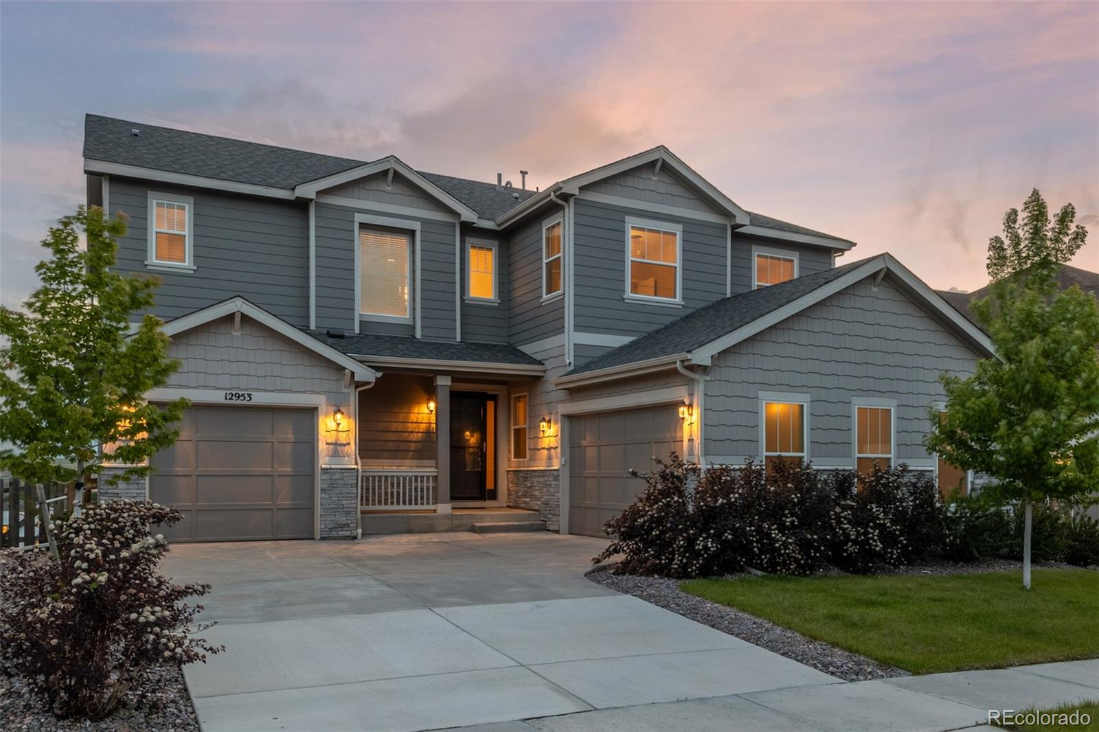 a front view of a house with a garden and plants