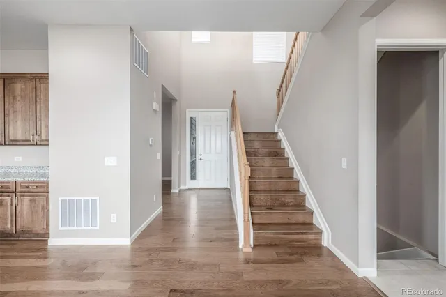 a view of a hallway with wooden floor and entryway