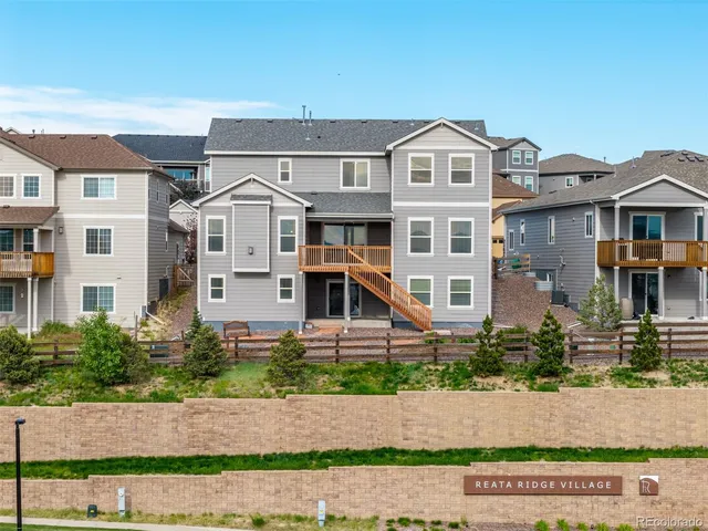 a front view of a house with a yard and potted plants
