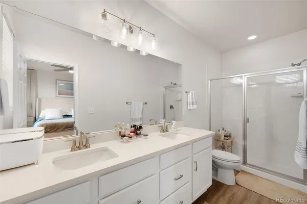 a bathroom with a double vanity sink toilet mirror and shower
