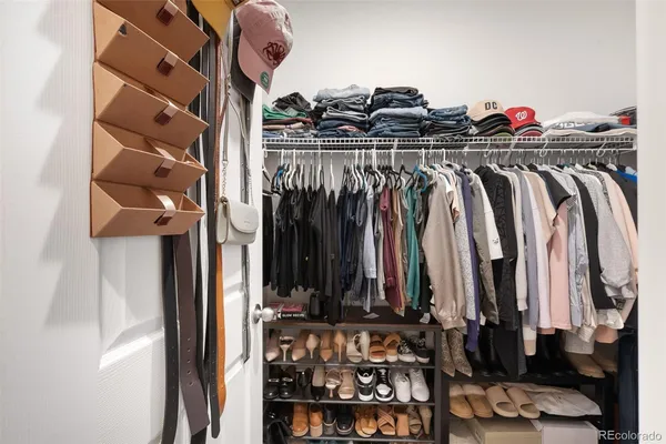 a view of walk in closet with clothes and shoes