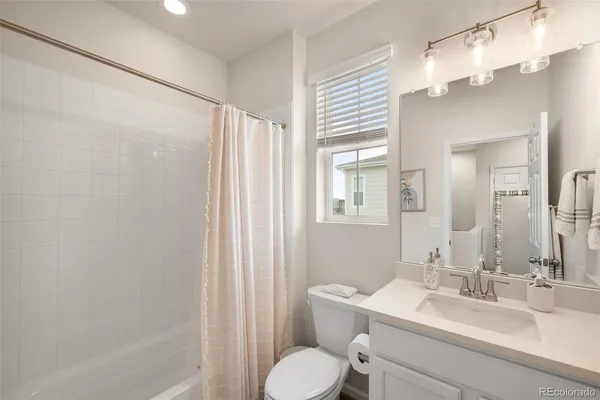 a bathroom with a granite countertop sink toilet a mirror and a tub