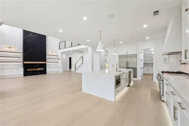 a kitchen with stainless steel appliances a sink a stove top oven a counter space and cabinets