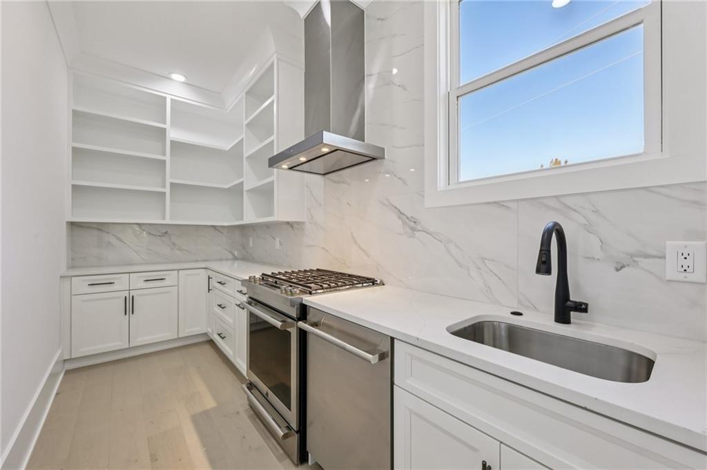 2395 Kilgore Road Buford, GA 30519 - Photo 20 of 68 a kitchen with stainless steel appliances granite countertop a sink and cabinets with wooden floor