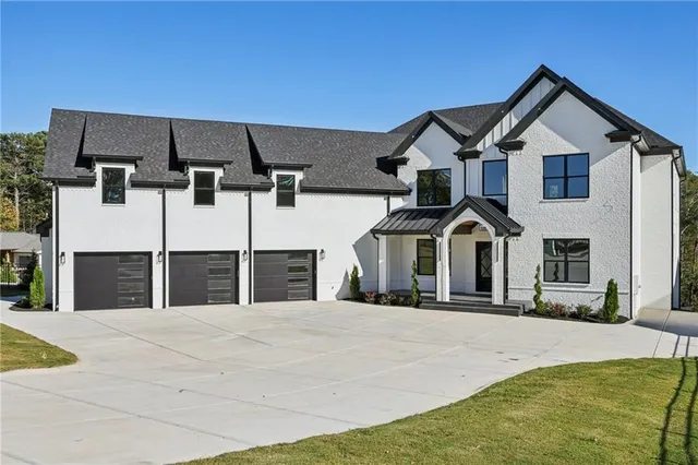 a view of a house with large windows and a yard