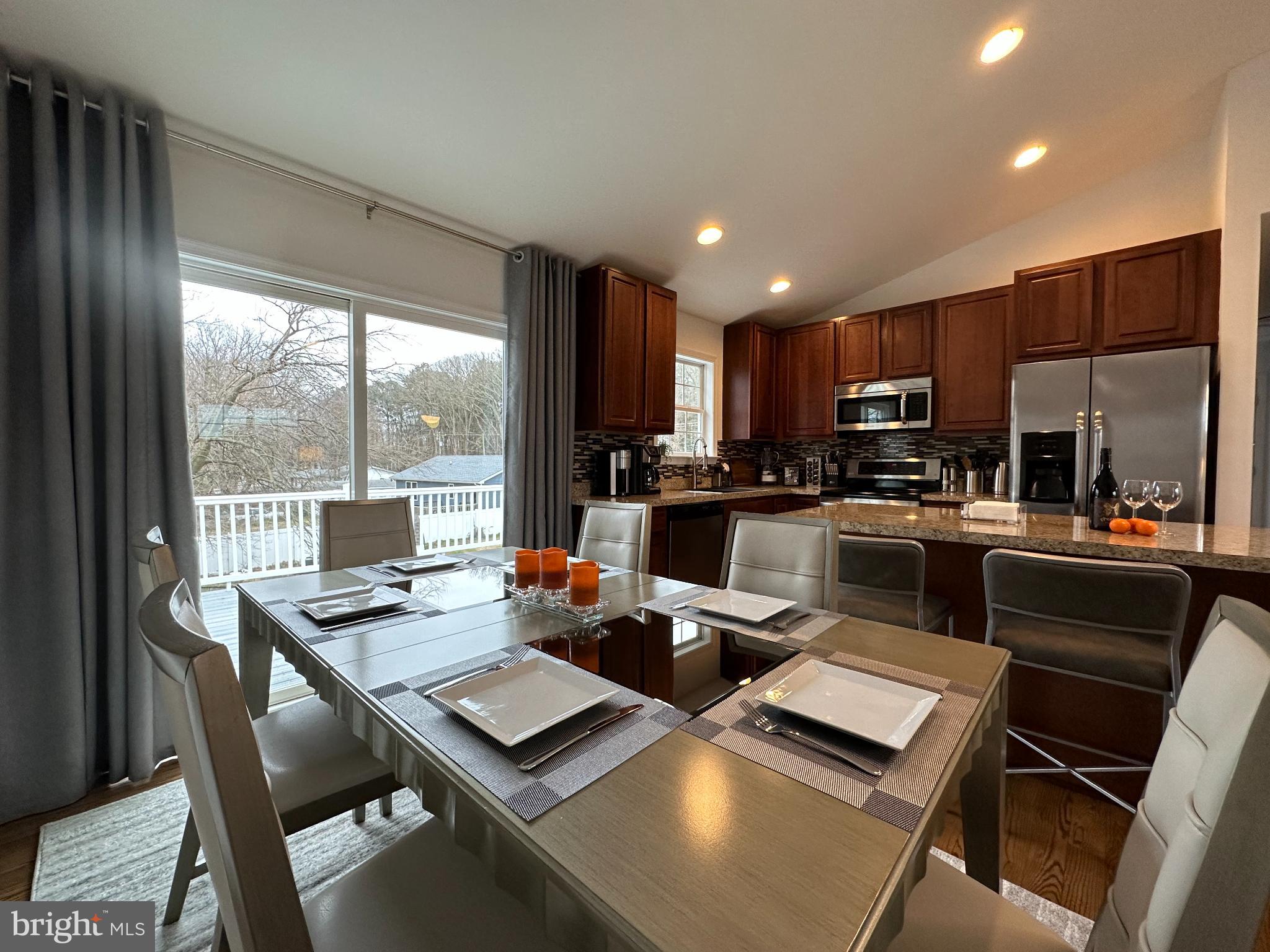 1221 Cox Neck Road Chester, MD 21619 - Photo 6 of 35 a kitchen with a table chairs microwave and refrigerator