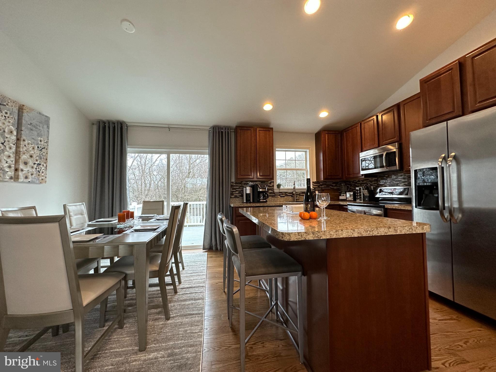 1221 Cox Neck Road Chester, MD 21619 - Photo 7 of 35 a kitchen with stainless steel appliances granite countertop a table chairs sink refrigerator and cabinets