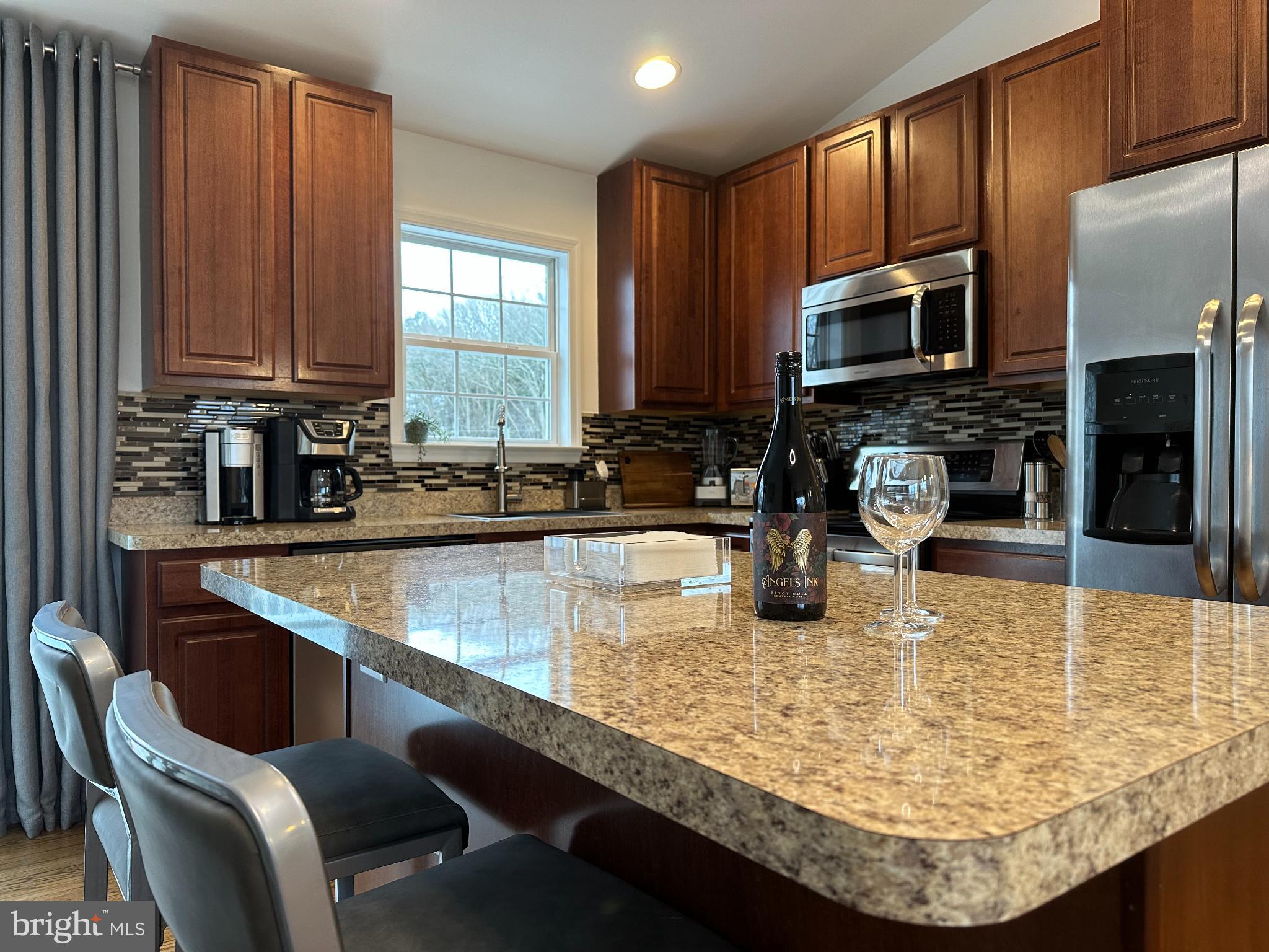 1221 Cox Neck Road Chester, MD 21619 - Photo 8 of 35 a kitchen with kitchen island granite countertop a sink stove and microwave