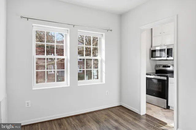 a view of kitchen with stainless steel appliances and wooden floor