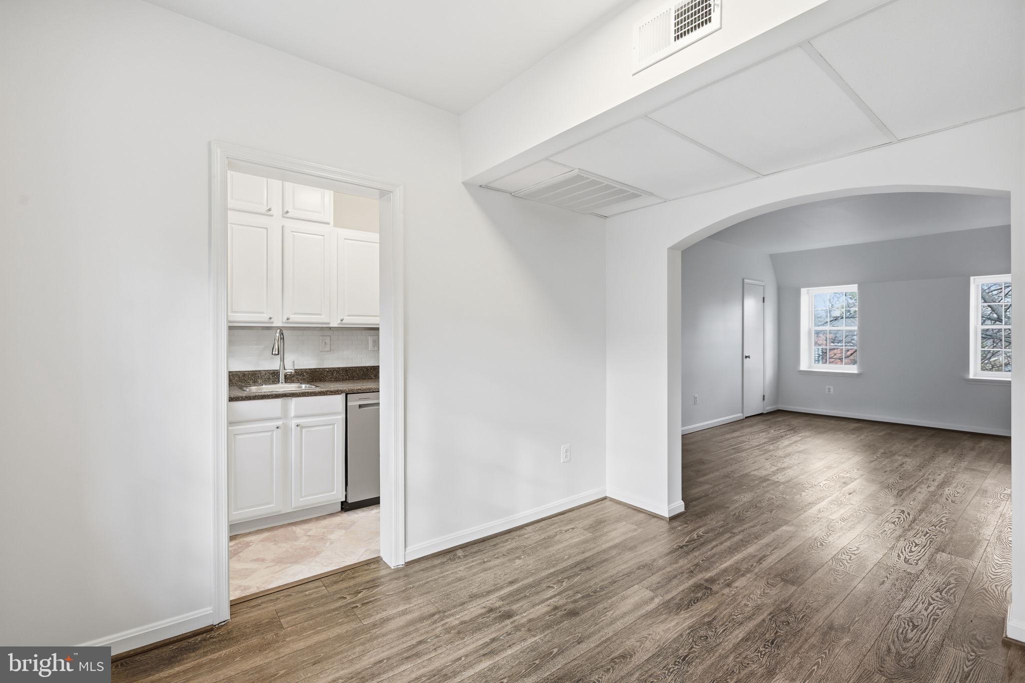 1744 North Rhodes Street, Unit 310 Arlington, VA 22201 - Photo 12 of 24 a view of a kitchen with a sink and dishwasher wooden floor