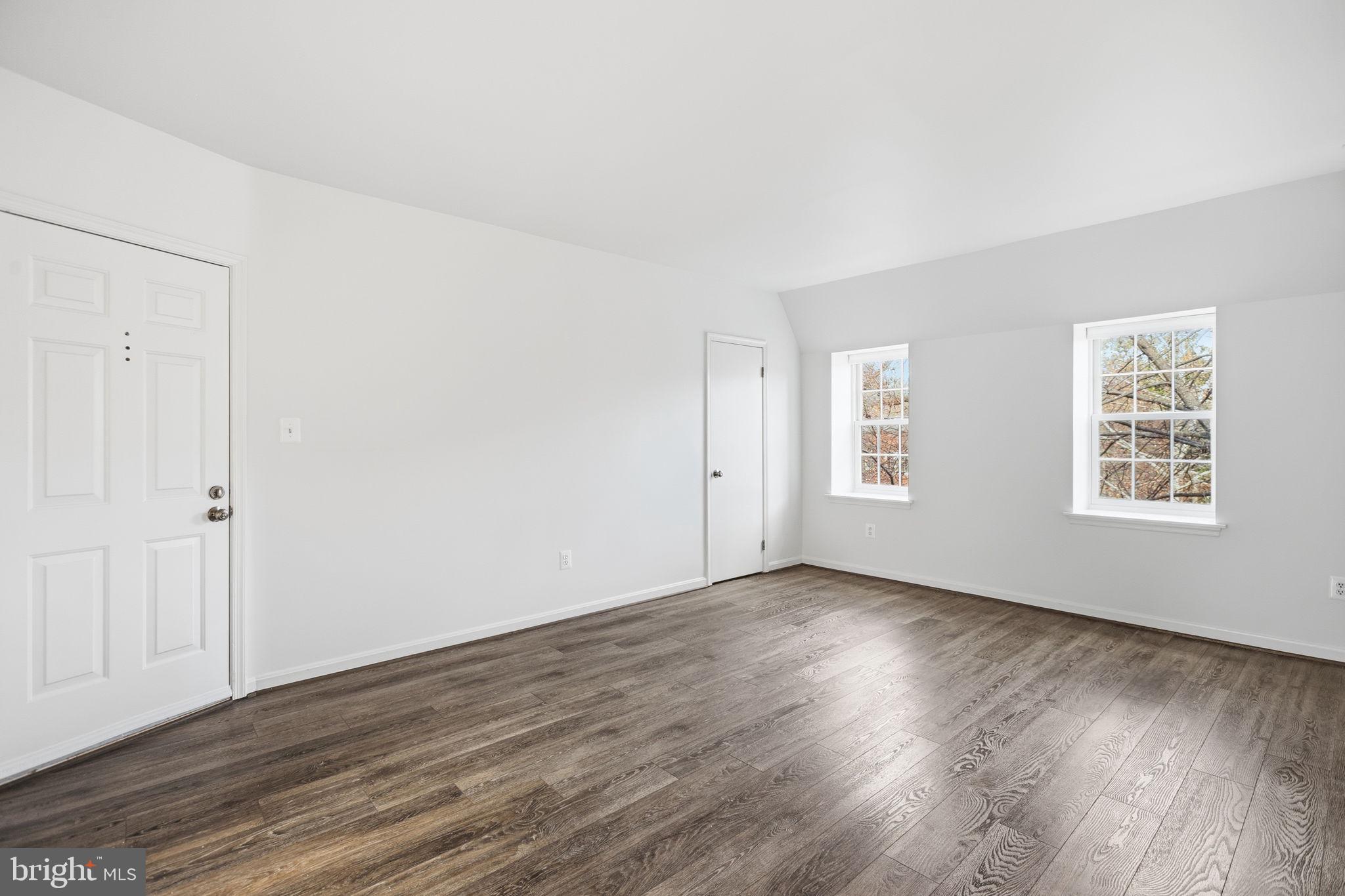 1744 North Rhodes Street, Unit 310 Arlington, VA 22201 - Photo 13 of 24 an empty room with wooden floor and windows