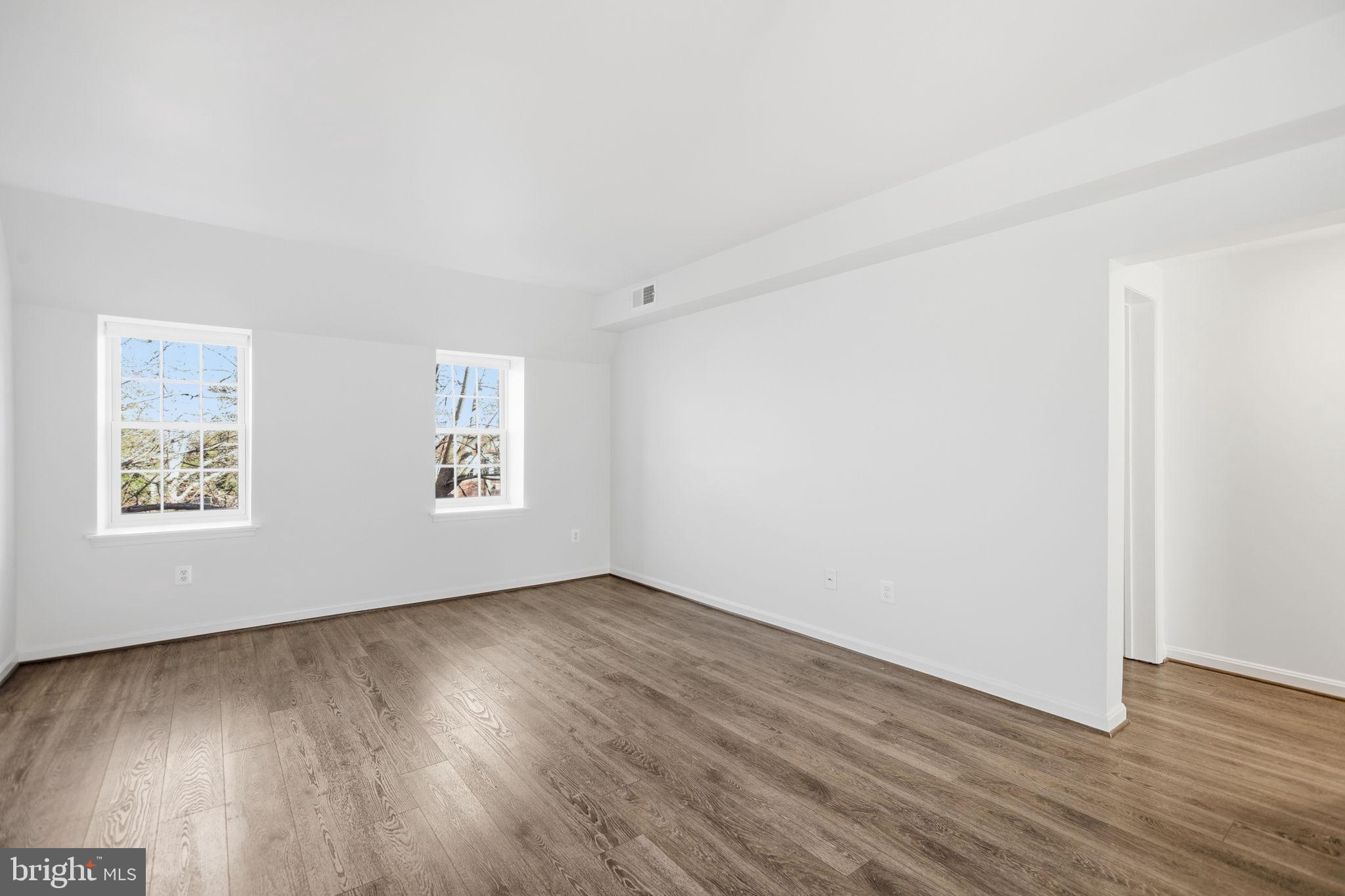 1744 North Rhodes Street, Unit 310 Arlington, VA 22201 - Photo 15 of 24 an empty room with wooden floor and windows