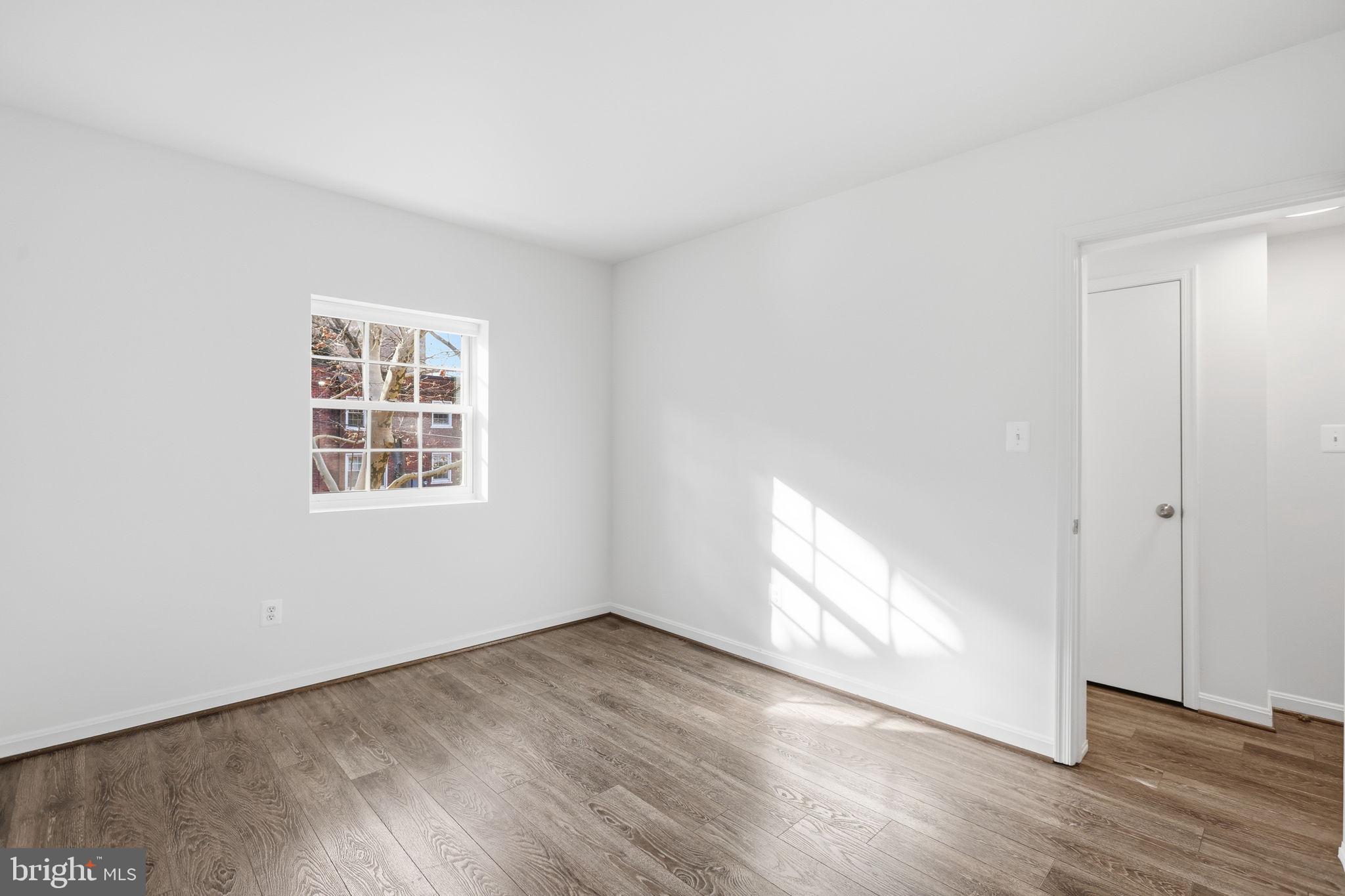 1744 North Rhodes Street, Unit 310 Arlington, VA 22201 - Photo 16 of 24 an empty room with wooden floor and windows