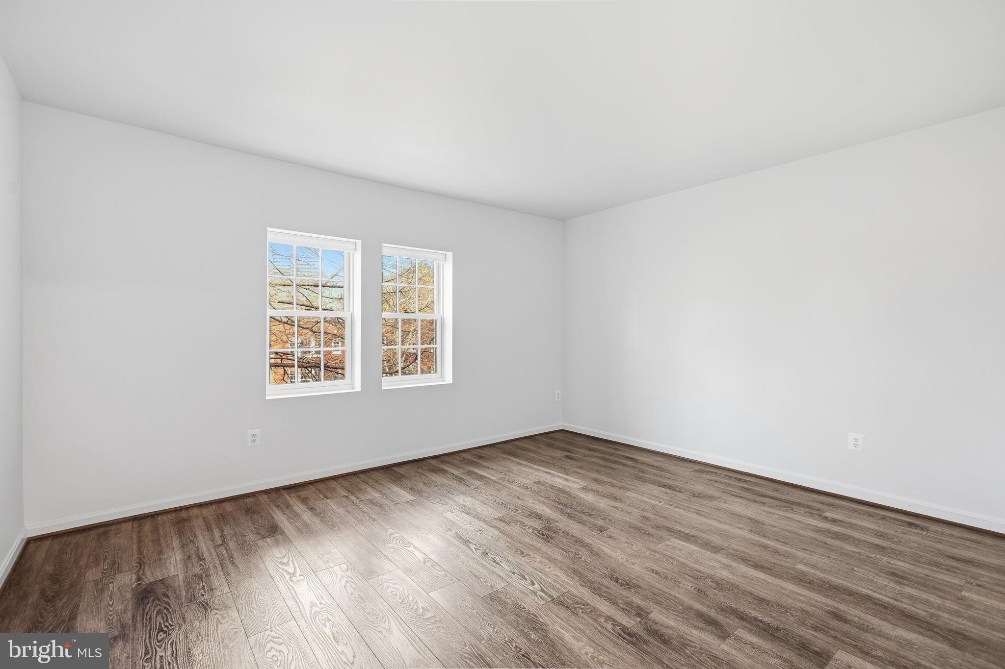 1744 North Rhodes Street, Unit 310 Arlington, VA 22201 - Photo 19 of 24 an empty room with wooden floor and windows