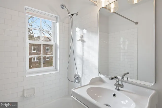 a bathroom with a sink tub and a mirror