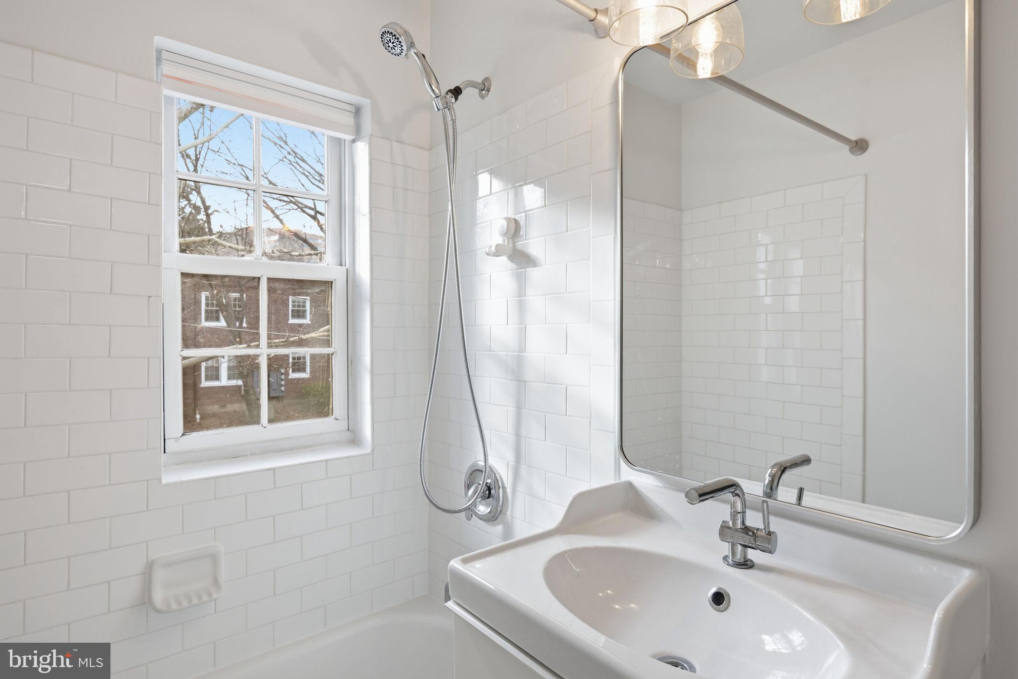 1744 North Rhodes Street, Unit 310 Arlington, VA 22201 - Photo 24 of 24 a bathroom with a sink tub and a mirror