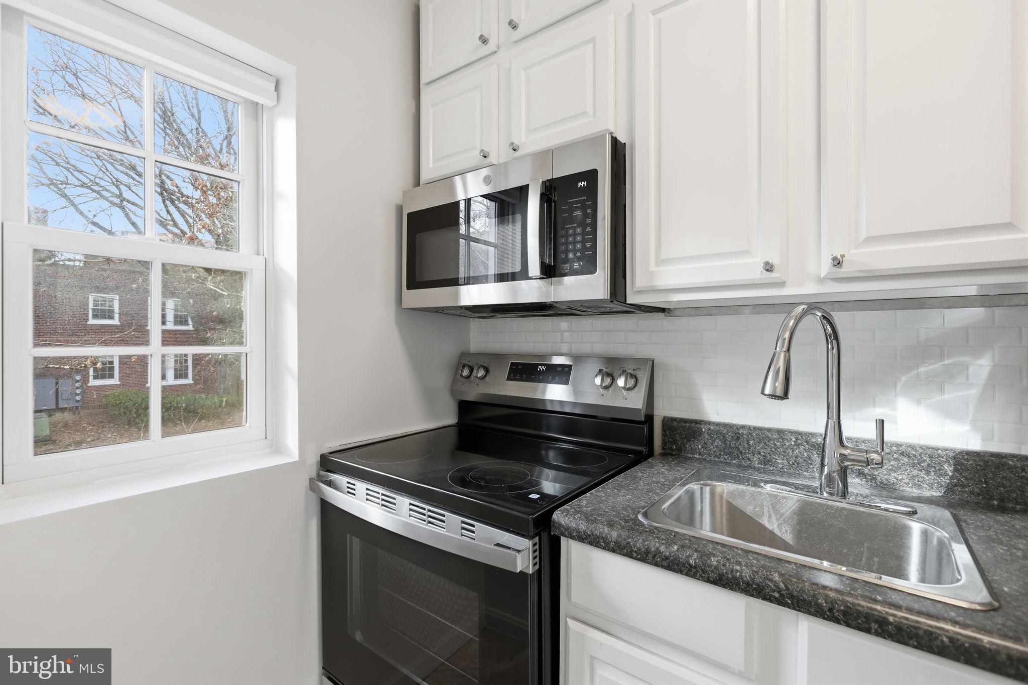 1744 North Rhodes Street, Unit 310 Arlington, VA 22201 - Photo 8 of 24 a kitchen with granite countertop a sink stainless steel appliances and cabinets