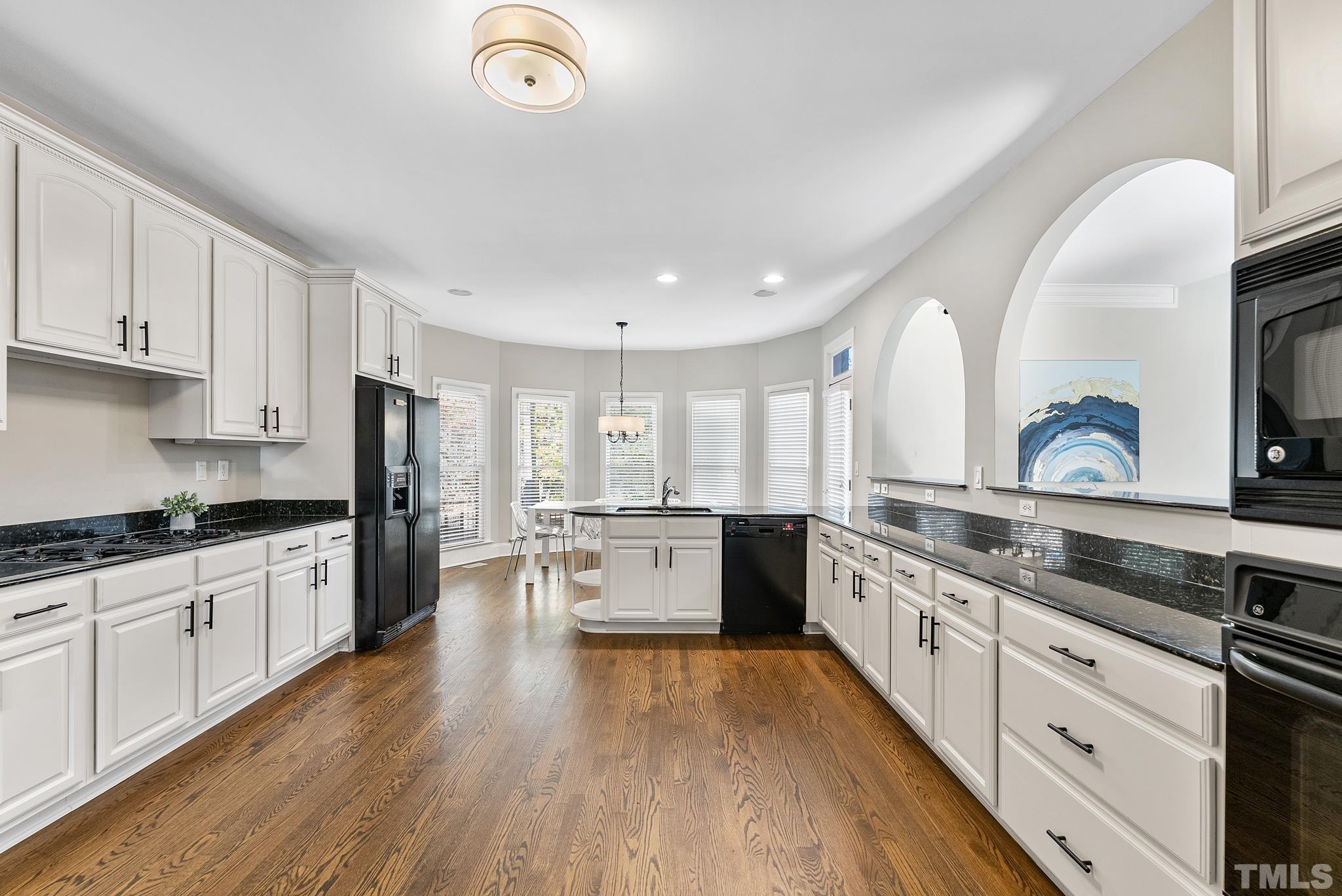 111 Redfern Drive Cary, NC 27518 - Photo 15 of 65 a large kitchen with a wooden floor and stainless steel appliances