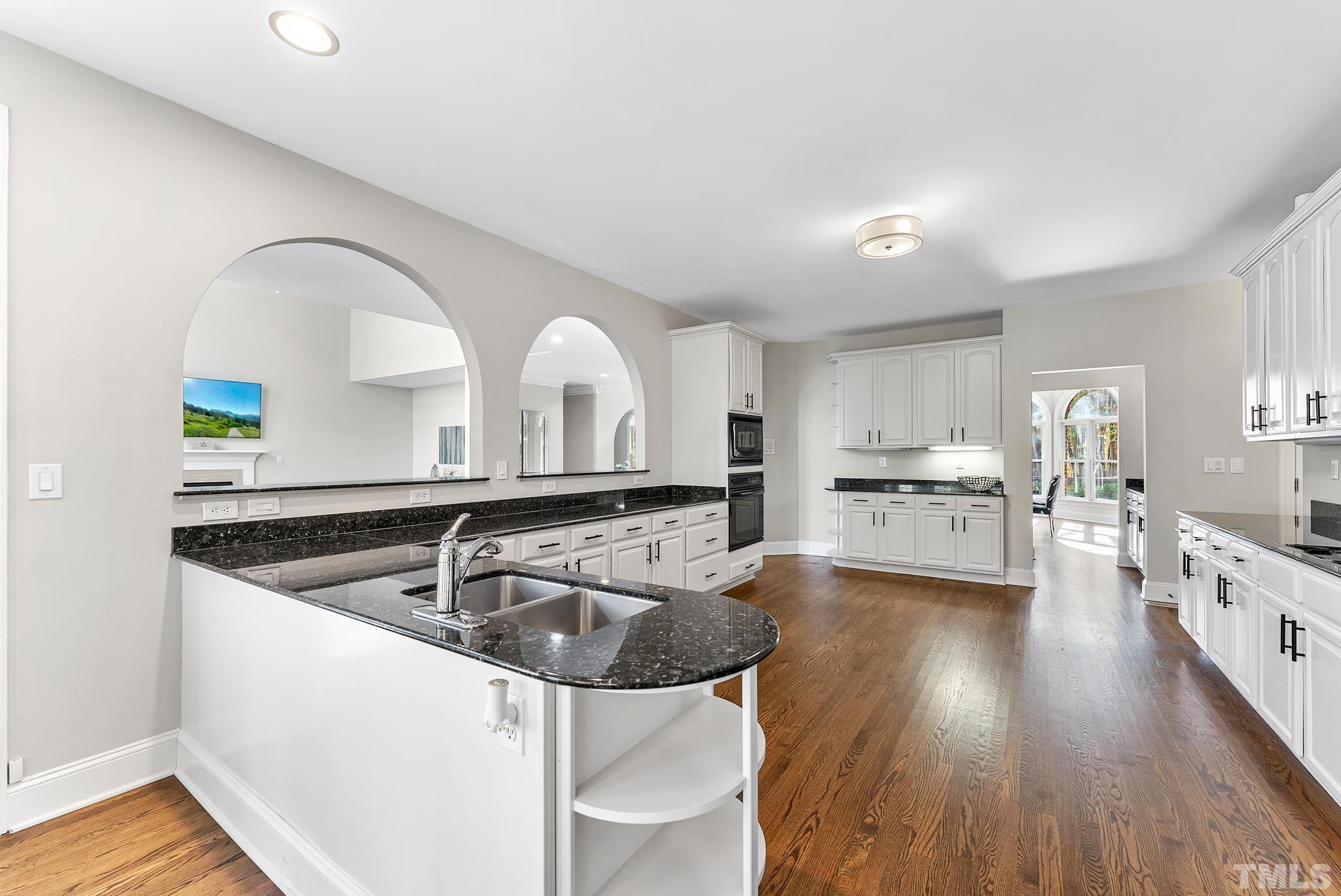 111 Redfern Drive Cary, NC 27518 - Photo 16 of 65 a kitchen with sink cabinets and wooden floor