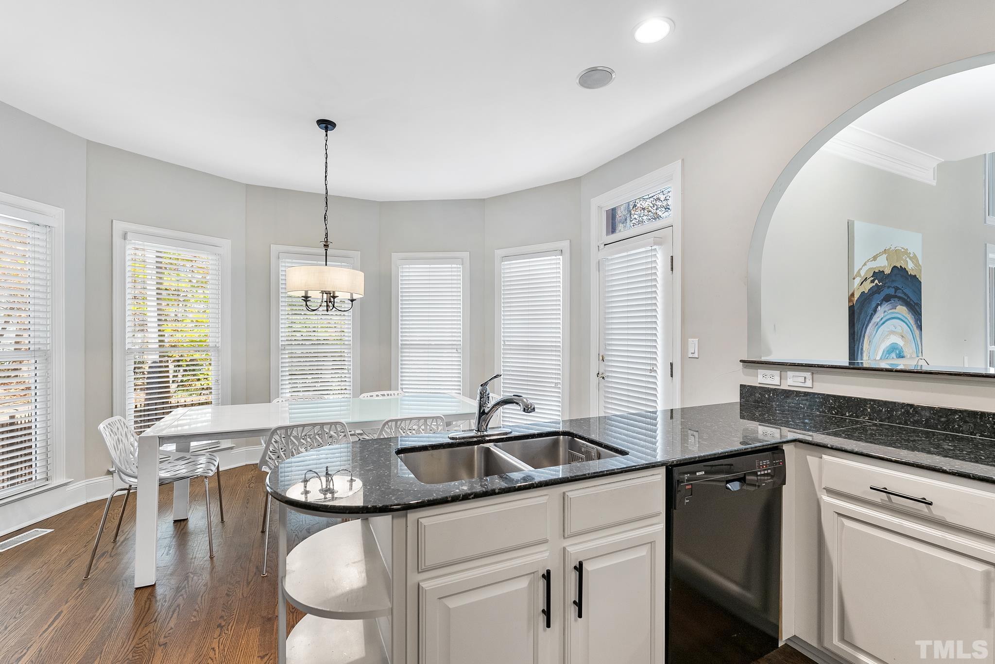 111 Redfern Drive Cary, NC 27518 - Photo 18 of 65 a kitchen with granite countertop a sink and white cabinets