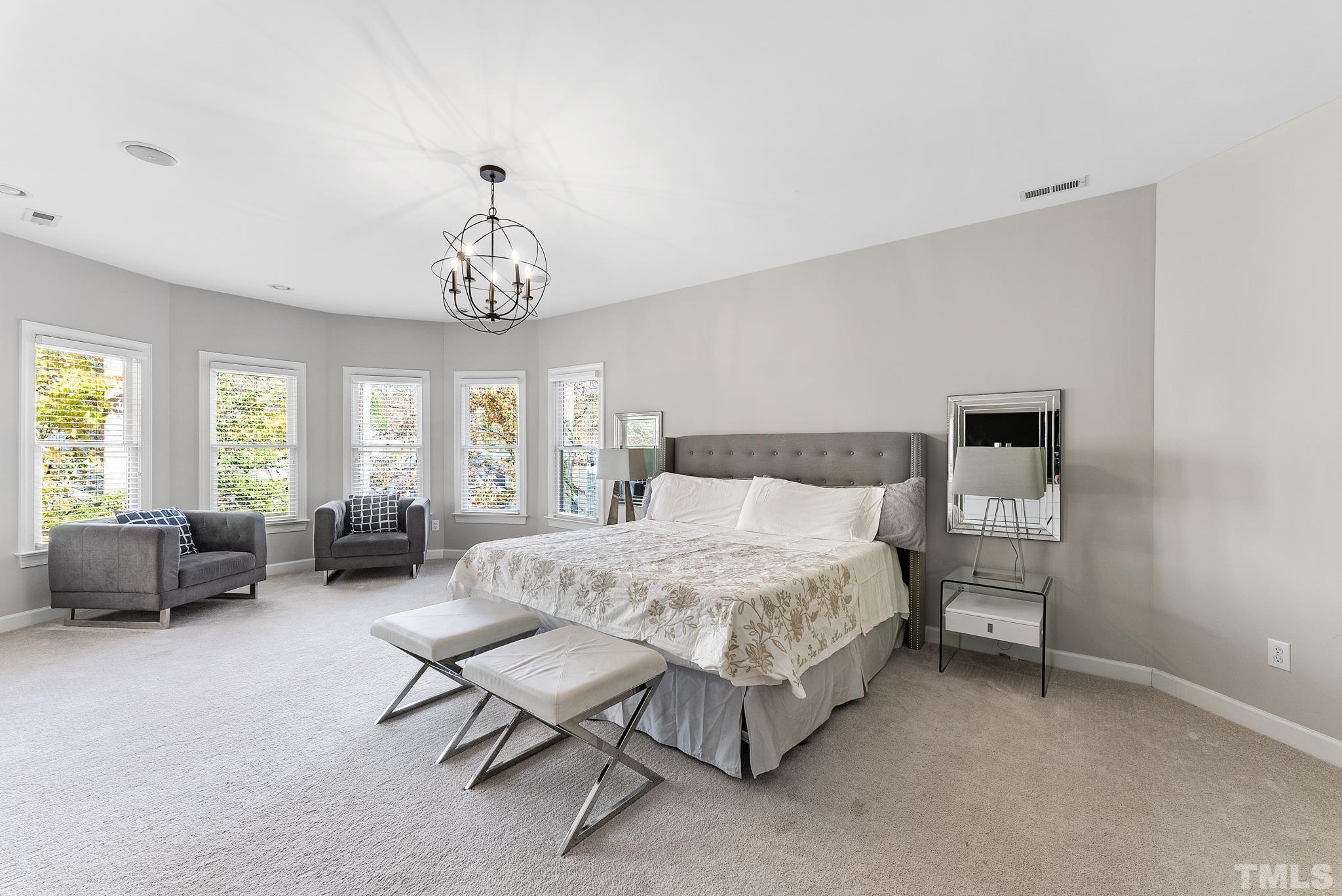 111 Redfern Drive Cary, NC 27518 - Photo 39 of 65 a spacious bedroom with a bed and a couch