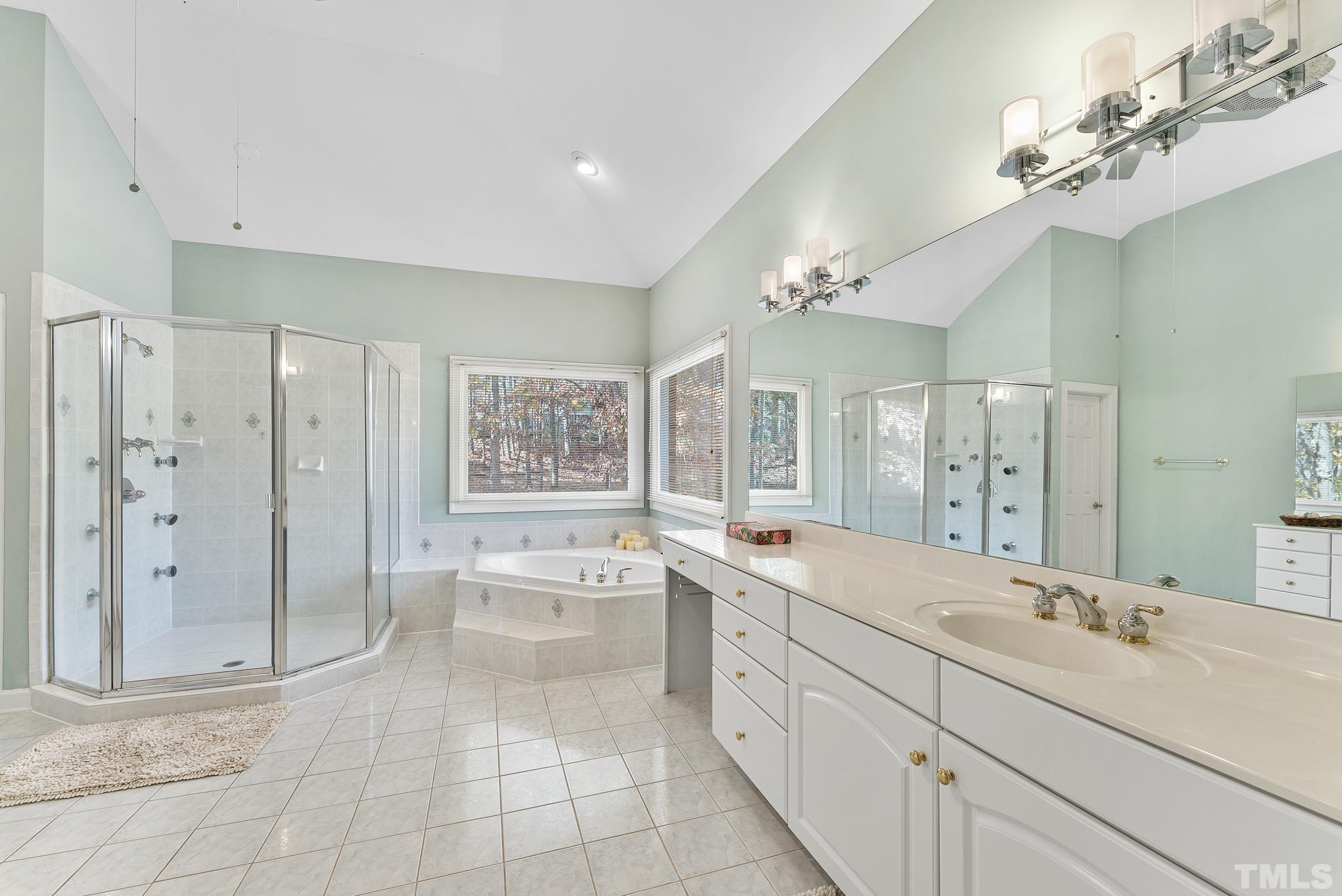 111 Redfern Drive Cary, NC 27518 - Photo 40 of 65 a spacious bathroom with a double vanity sink a large mirror and a bathtub
