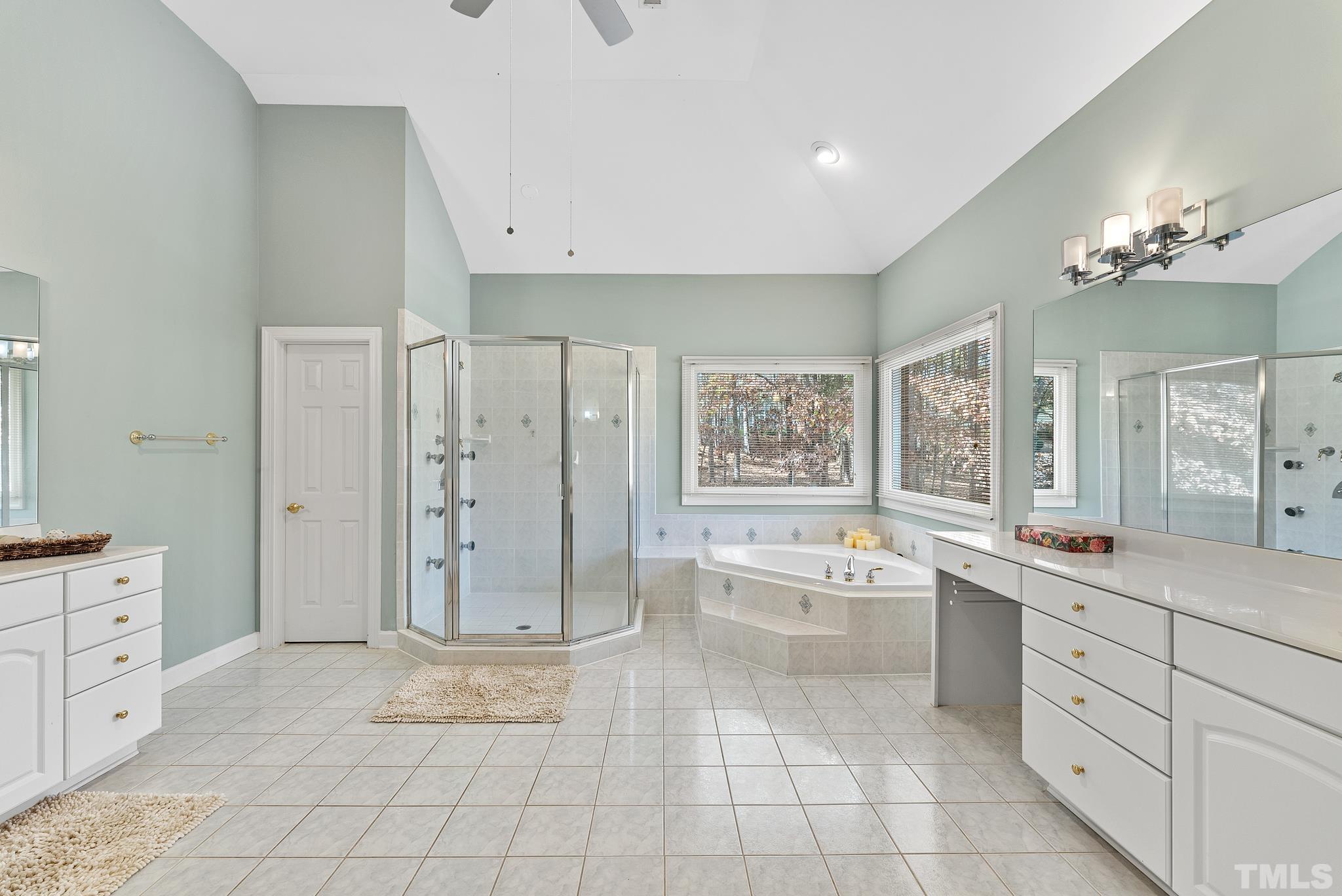 111 Redfern Drive Cary, NC 27518 - Photo 41 of 65 a large white bathroom with a granite countertop sink a toilet a mirror and bathtub
