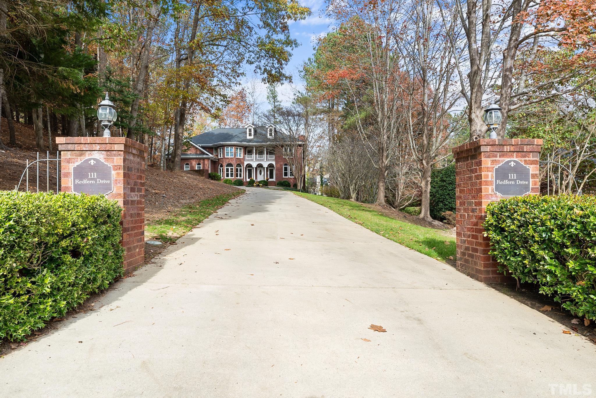 111 Redfern Drive Cary, NC 27518 - Photo 63 of 65 a front view of a building with a garden and trees