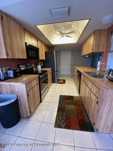 2671 Royal Ridge Drive Spring Hill, FL 34606 - Photo 12 of 34 a kitchen with stainless steel appliances a sink a stove top oven a chimney and cabinets