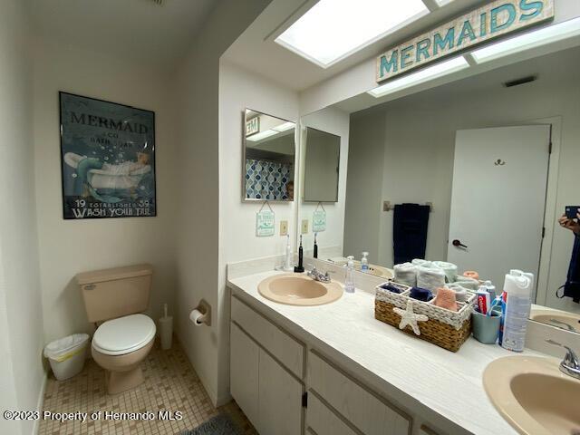 2671 Royal Ridge Drive Spring Hill, FL 34606 - Photo 20 of 34 a bathroom with a toilet a sink and mirror
