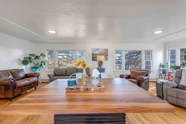 a view of a dining room with furniture a chandelier and wooden floor