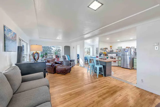 a living room with furniture and a dining table with kitchen view